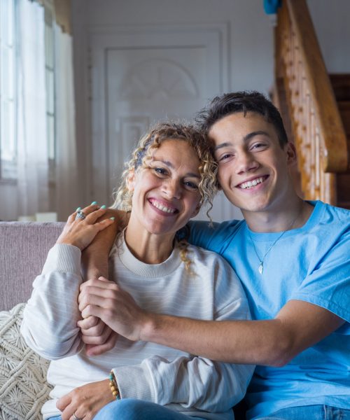 Portrait of grateful teenager man hug smiling middle-aged mother show love and care, thankful happy grown-up son in embrace cheerful mom, enjoy weekend family time at home together, bonding concept